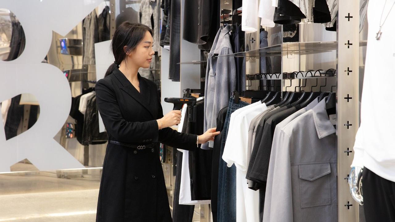 Person scanning apparel in retail store