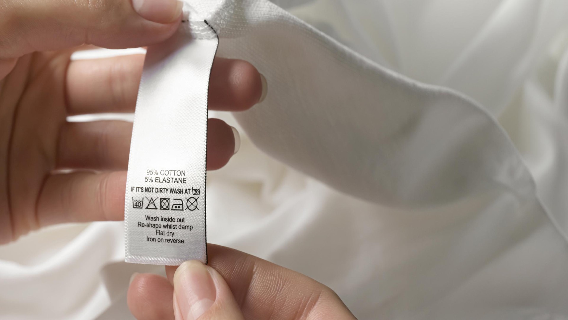 person looking at a garment care label